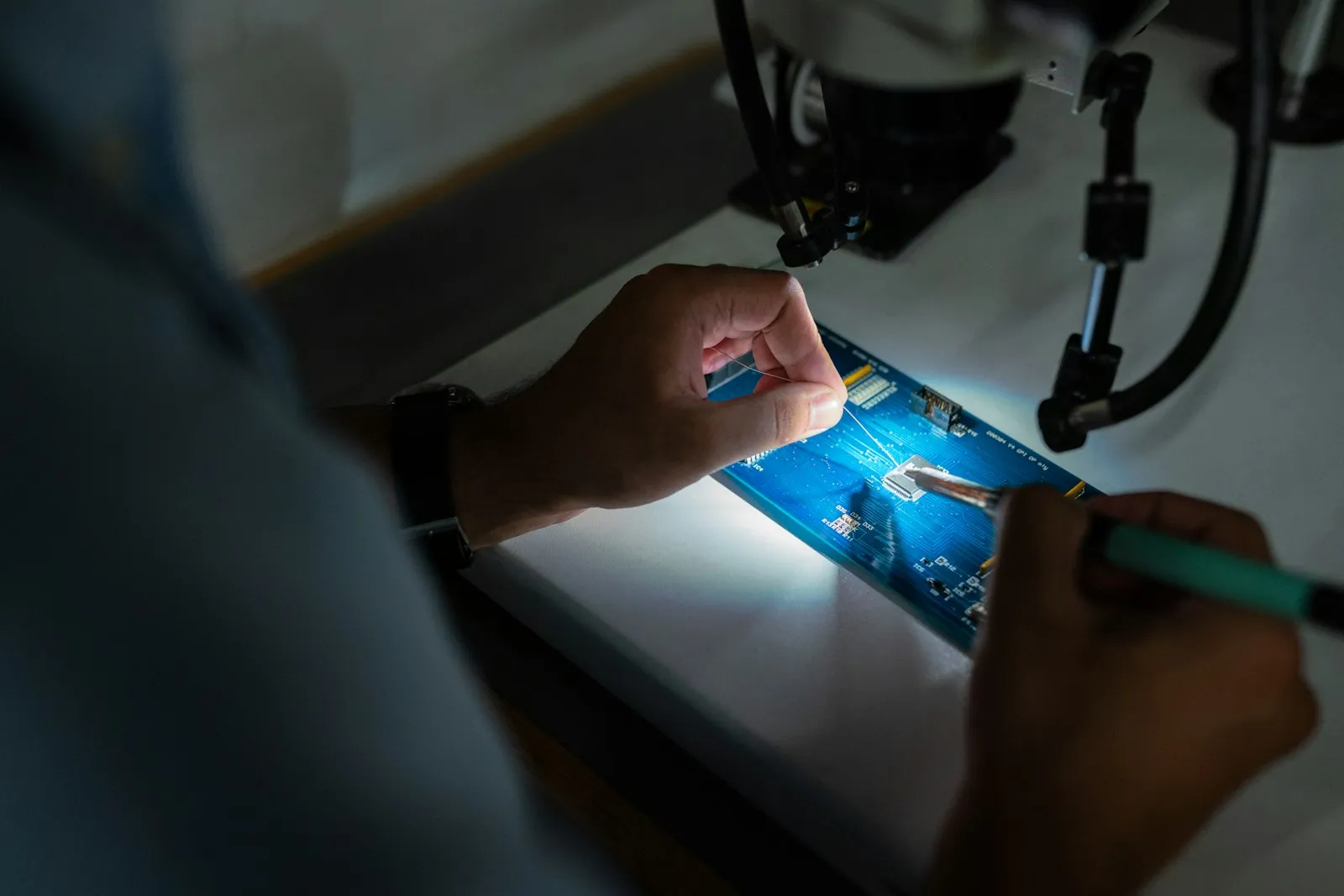 Engineer assembling a HeatGo sensor circuit board under a microscope